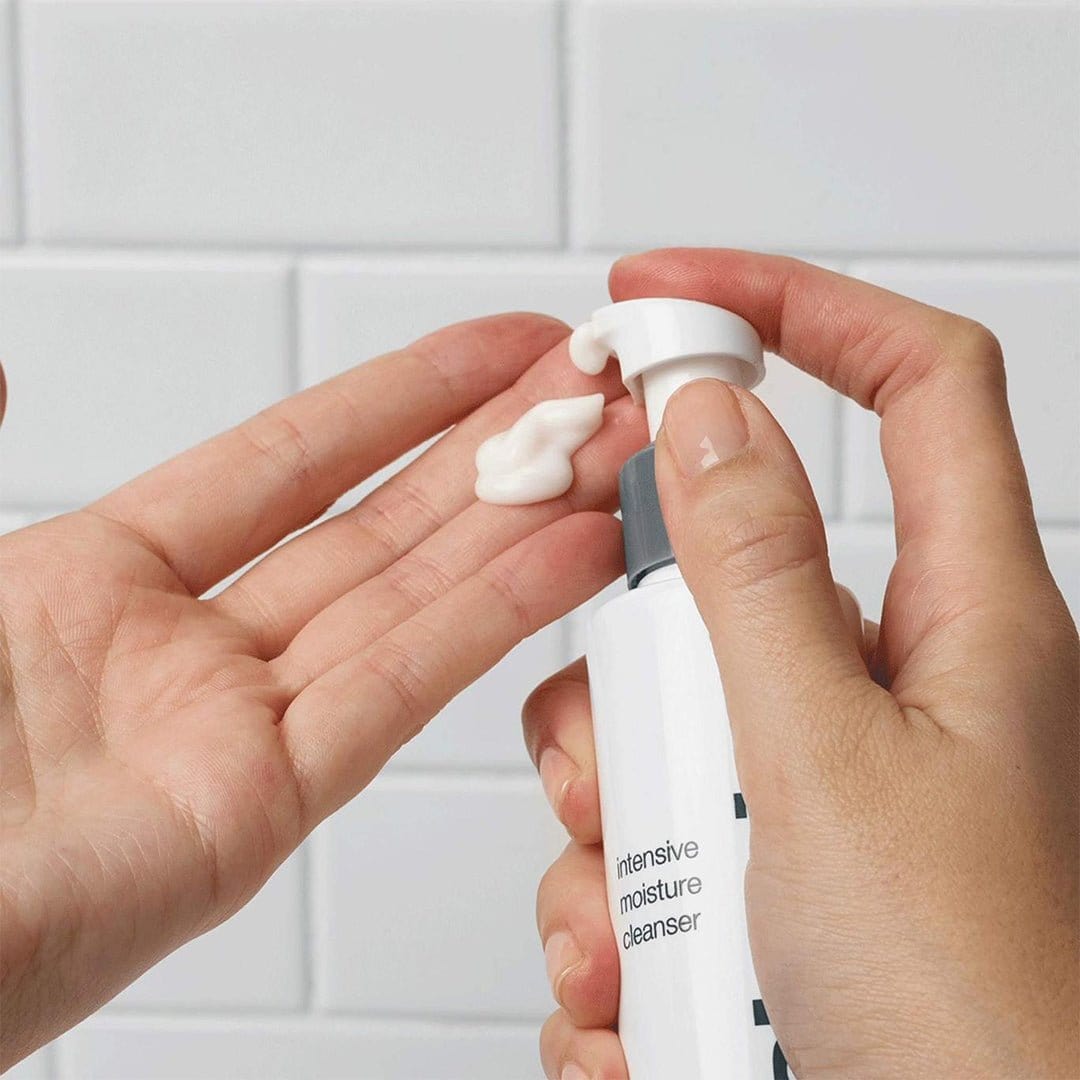 Jemand gibt Intensive Moisture Cleanser auf seine Hand, ideal für trockene Haut, im Hintergrund eine weiß geflieste Wand.