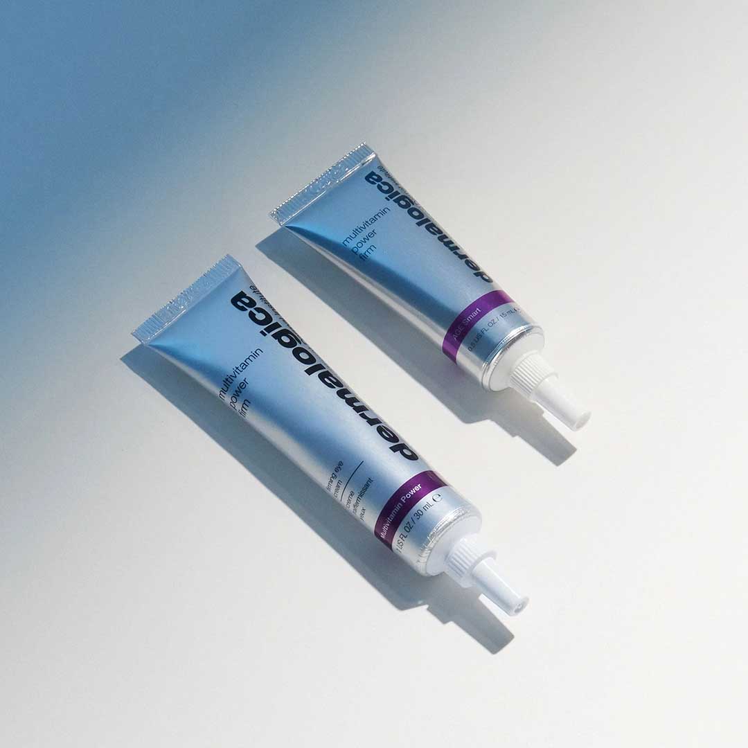 Zwei metallisch blaue Tuben Dermalogica Retinol Clearing Oil mit weißen und lilafarbenen Akzenten liegen parallel auf einer hellen Fläche - perfekt zur Kombination mit MultiVitamin Power Firm für straffere, jugendlicher aussehende Augenkonturen.