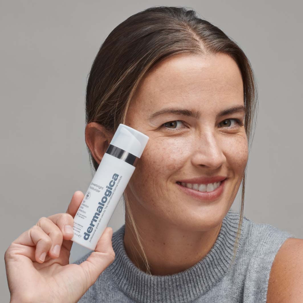 Lächelnde Person hält ein Produkt der Marke in der Hand.