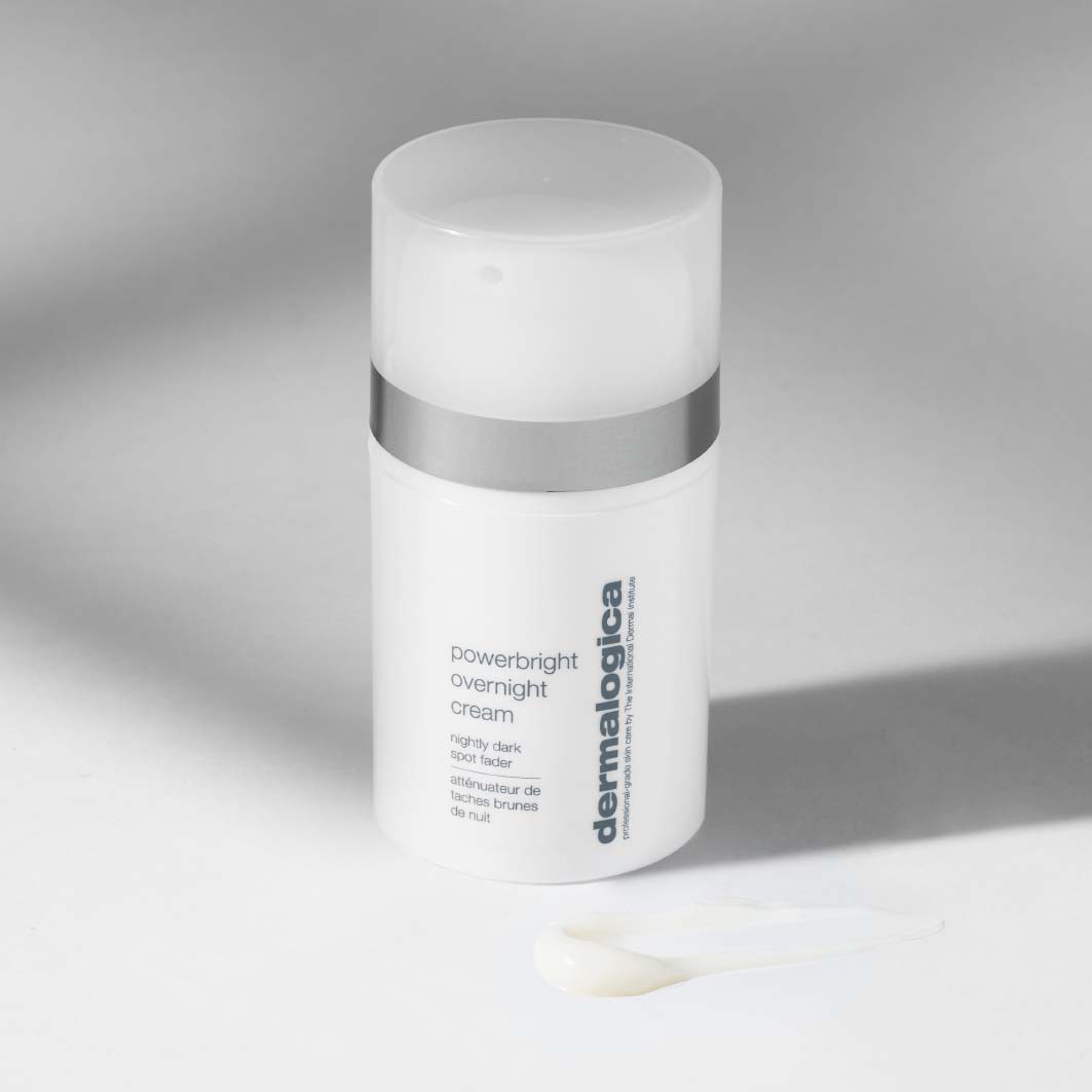 Weiße Flasche der Powerbright Overnight Cream mit einer kleinen Menge Creme davor auf hellem Untergrund.