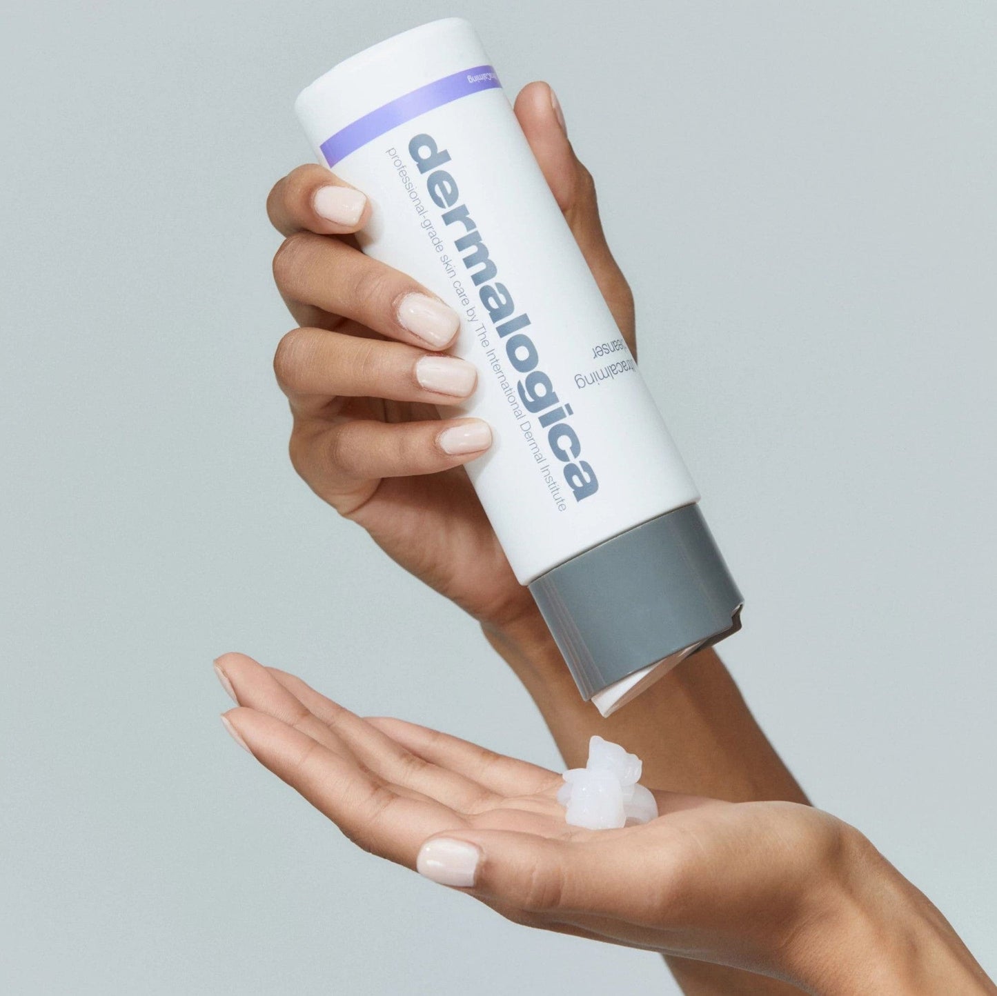 Hand hält Hautpflegeprodukt-Flasche und dosiert Produkt auf die andere Handfläche.