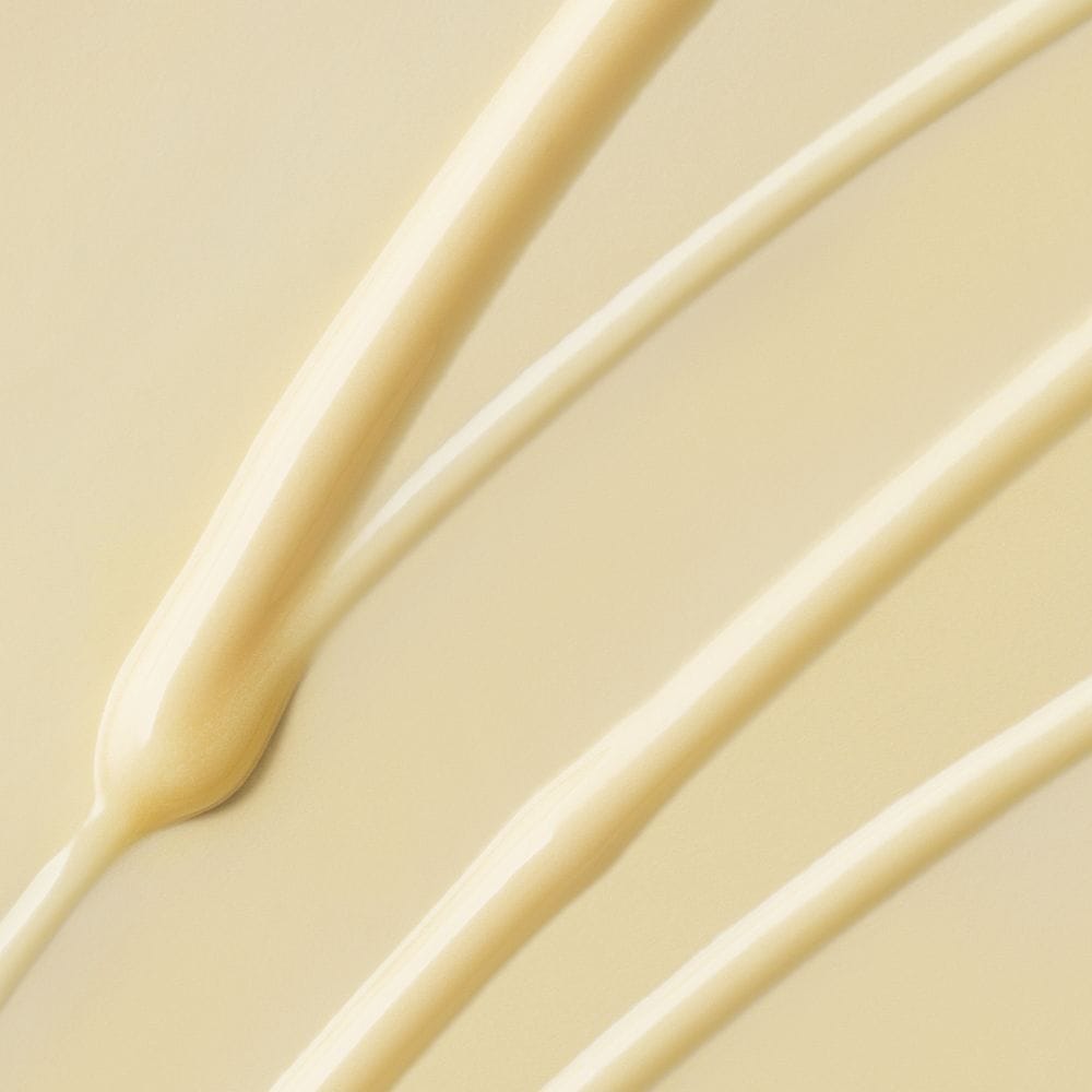 Nahaufnahme mehrerer dicker, cremefarbener, beigefarbener Flüssigkeitslinien, die der Formel des Deep Breakout Liquid Patch ähneln und auf einer glatten, hellen Oberfläche verteilt sind.