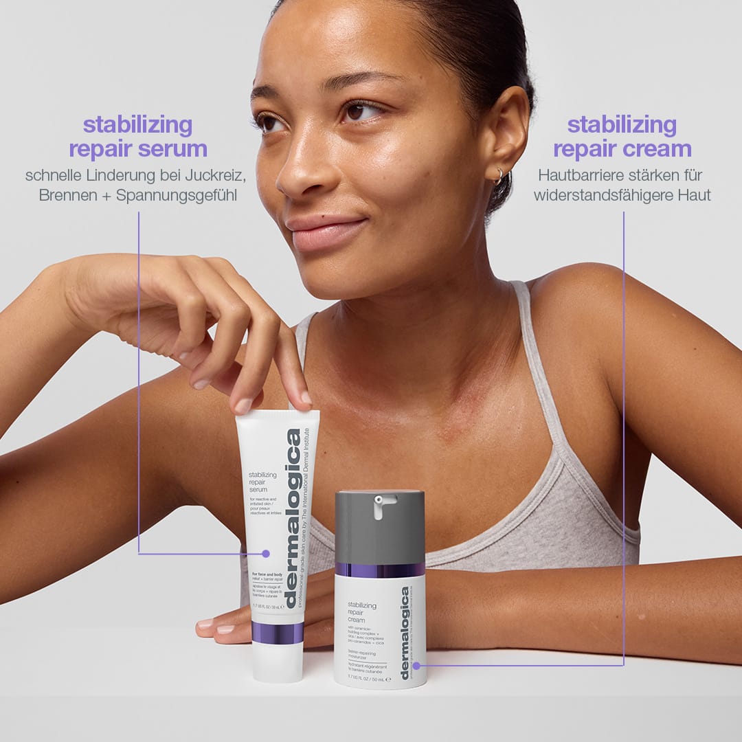 Eine Frau in einem ärmellosen Oberteil hält vor einem neutralen Hintergrund Flaschen mit dem „Stabilizing Repair Serum“ – mit kolloidalem Hafermehl zur Stärkung der Hautbarriere – und der „Stabilizing Repair Cream“ in der Hand.