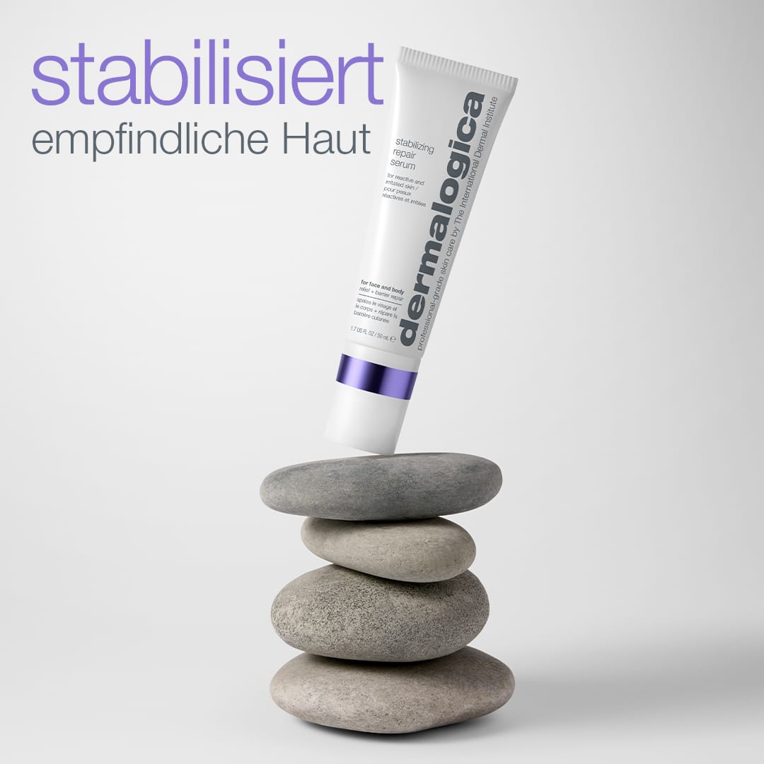 Eine Tube „Stabilizing Repair Serum“, die auf grauen Steinen balanciert, im Hintergrund die Aufschriften „stabilisiert empfindliche Haut“ und „Hautbarriere stärken“.