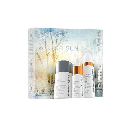 Das Warmth of the Winter Sun Set enthält drei essentielle Hautpflegeprodukte in weißen Flaschen, darunter ein Vitamin-C-Serum und SPF 50, in einer winterlichen Box - ideal als Glow & Schutz Travel-Set.
