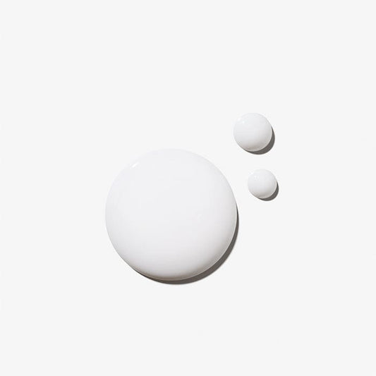 Drei verschieden große Tropfen einer weißen Flüssigkeit auf einem einfarbigen Hintergrund.