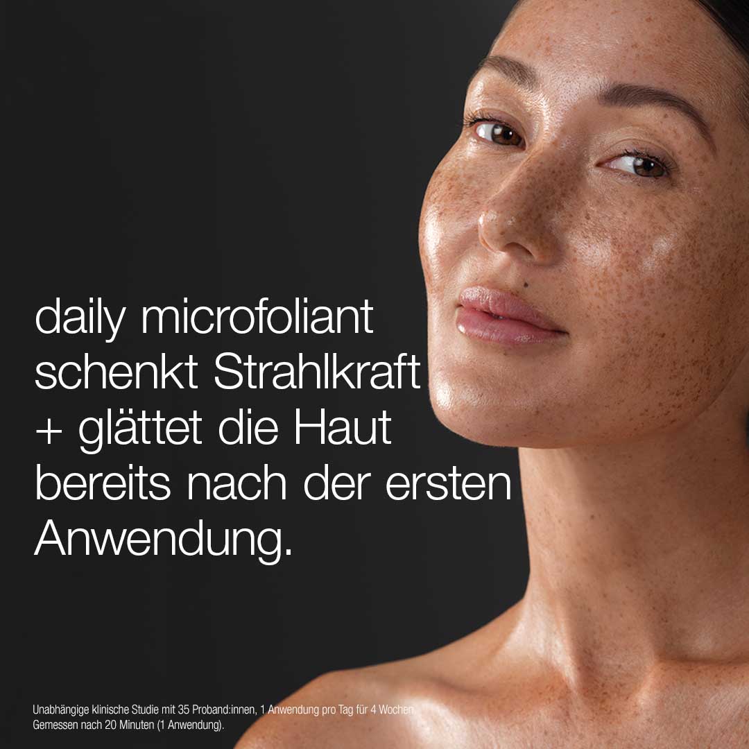 Eine Frau mit klarer, strahlender Haut blickt in die Kamera. Text: "daily microfoliant schenkt Strahlkraft + glättet die Haut ab der ersten Anwendung - ideal mit dem Warmth of the Winter Sun Set für leuchtende Haut unterwegs.