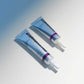 Zwei metallisch blaue Tuben Dermalogica Retinol Clearing Oil mit weißen und lilafarbenen Akzenten liegen parallel auf einer hellen Fläche - perfekt zur Kombination mit MultiVitamin Power Firm für straffere, jugendlicher aussehende Augenkonturen.