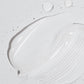 Eine Nahaufnahme der weißen Creme aus dem Sensitive Rescue Kit, die mit Wassertropfen auf eine strukturierte Oberfläche aufgetragen wurde – perfekt für empfindliche Haut und inspiriert von Dermalogica Produkten für ultimative Feuchtigkeit.