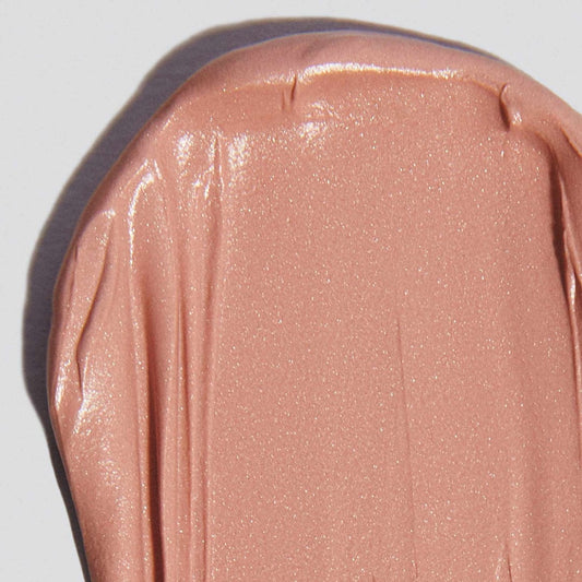 Eine Nahaufnahme der glatten, schimmernden, nudefarbenen SkinPerfect Primer SPF 30 Creme, die auf eine weiße Fläche aufgetragen wurde.