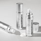 Drei silberne Flaschen Smart Response Serum werden auf einer weißen Fläche präsentiert; zwei stehen aufrecht, während eine liegt, neben der das Serum ausgegeben wurde.