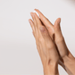 Zwei Hände mit Handcreme auf dem Handrücken.