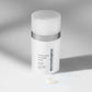Weiße Flasche der Powerbright Overnight Cream mit einer kleinen Menge Creme davor auf hellem Untergrund.
