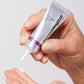 Hand drückt eine kleine Menge Creme aus einer Tube der Marke Multivitamin Power Firm heraus.