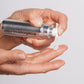 Eine Hand drückt eine Lotion oder Creme der Marke aus einem Spender auf den Handrücken einer anderen Hand.