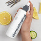 Eine Hand hält eine Flasche Multi-Active Toner neben Zitronenschnitzen und Gurkenscheiben auf einem hellen Hintergrund.
